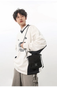 Detail of black nylon functional crossbody bag featuring front mesh pocket and adjustable cord