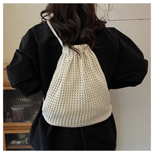 Detail of hollow crochet drawstring backpack in cream white with woven mesh texture