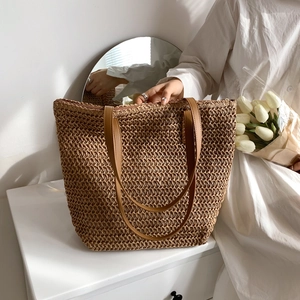 Détail du sac cabas en paille tissé main avec anses en cuir marron et fermeture