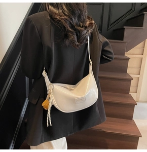 Sac hobo blanc en similicuir avec détail de corde tressée sur l'épaule d'un modèle