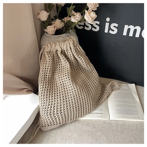 Detail of beige crochet hollow-out backpack with drawstring and rustic bohemian style