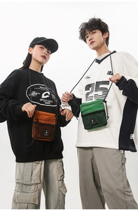 Close-up of orange and green mini messenger bags with mesh pockets and fabric texture