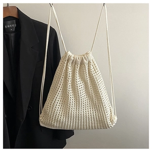 Detail of beige hollow mesh woven backpack with drawstring closure and soft texture