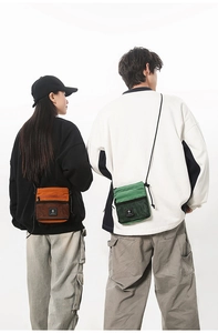Detail view of mini crossbody bags in orange and green with mesh pockets and adjustable straps
