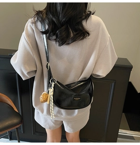 Détail du sac cabas croissant en similicuir noir avec zip argenté et breloque ourson
