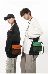 Detailed view of unisex functional nylon crossbody bags in vibrant orange and green colors