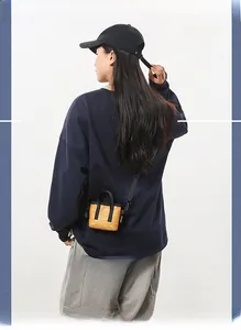 Modèle portant un mini sac bandoulière jaune moutarde montrant la taille de dos