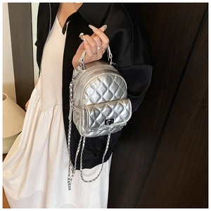 Detail of silver metallic quilted mini backpack with chain strap and twist lock closure