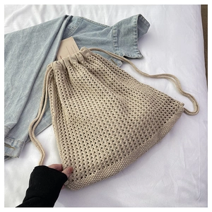 Close-up of beige hollow-out woven texture and drawstring closure on the summer bucket bag