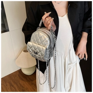 Close-up of silver quilted mini backpack featuring metallic texture and chain straps
