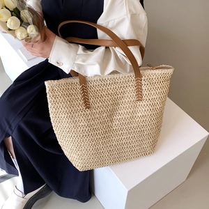Gros plan sur la texture tissée main et la bandoulière en cuir marron avec surpiqûres