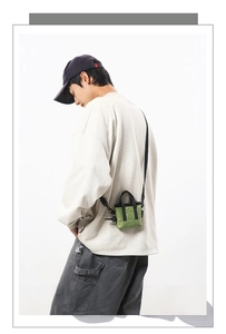 Détail d'un mini sac cabas vert herbe montrant la texture toile et la bandoulière