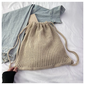 Detail of hollow knit mesh backpack in cream white with drawstring closure and soft texture