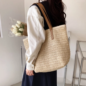 Détail du sac seau tissé à la main avec poignées en cuir marron style vacances