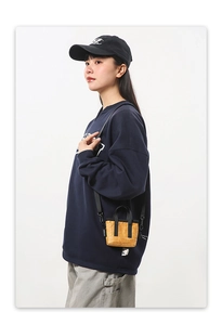 Détail d'un mini sac bandoulière jaune vif texturé avec poignées et sangle en sangle noire