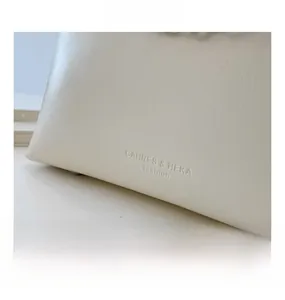 Détail de la texture en cuir PU beige avec logo embossé sur un sac seau élégant et chic