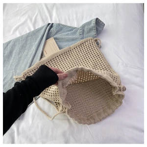 Close-up of the beige hollow-out crochet mesh texture and spacious bucket bag interior
