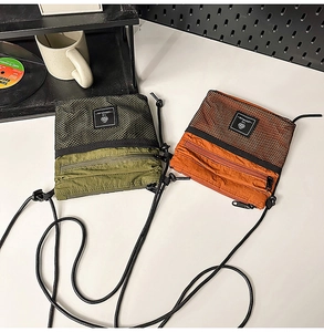 Detail of olive green and burnt orange tactical nylon crossbody bags with mesh pockets