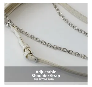 Détail de la bandoulière réglable blanc crème avec chaîne argentée et boucle en métal