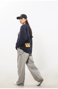 Mini sac bandoulière jaune avec anses noires porté par un mannequin pour un look décontracté