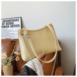 Détail du sac bandoulière crème avec chaîne argentée et bandoulière réglable