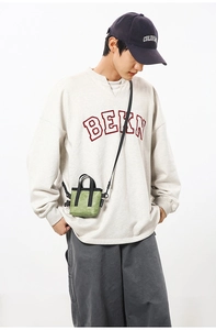 Détail du mini sac bandoulière vert herbe avec poignée noire et tissu à texture
