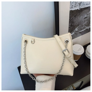 Détail du sac seau en cuir crème avec chaîne argentée et bandoulière réglable pratique