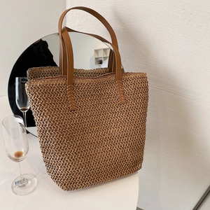 Détails du tissage en paille et de la poignée en cuir avec coutures renforcées