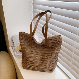 Détail du tissage du sac cabas en paille avec des bandoulières en cuir marron
