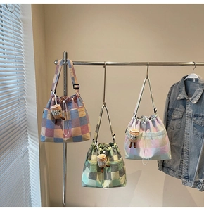 Close-up of stylish striped tote bags with drawstring closure and cute plush charms