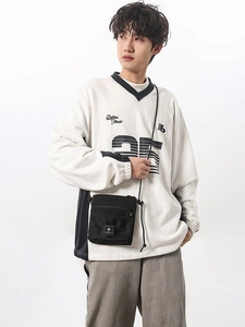 Men's black tactical crossbody bag with mesh zip pocket on a white sweatshirt model