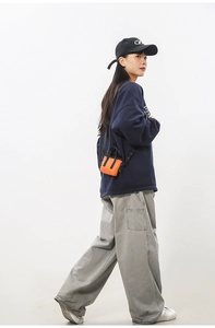 Mini sac cabas bandoulière orange et noir en nylon porté par un mannequin au style urbain