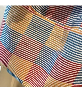 Macro detail showing colorful plaid canvas fabric and neat quilted stitching texture
