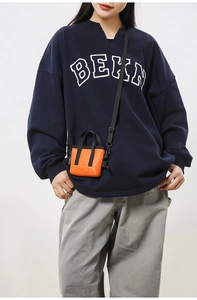 Détail du mini sac cabas en nylon orange vif avec sangles noires et texture matelassée