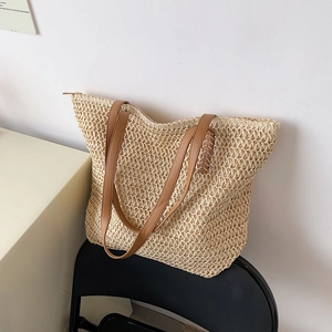 Détail du sac cabas en paille tissée avec anses en similicuir marron et fermeture éclair