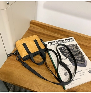 Détail du sac bandoulière jaune froissé avec sangle réglable sur une table en bois