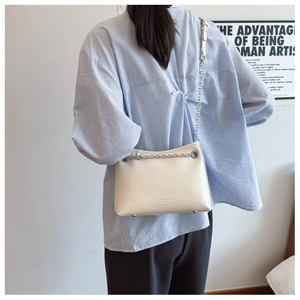 Détail du sac bandoulière blanc en cuir avec chaîne argentée et sangle réglable