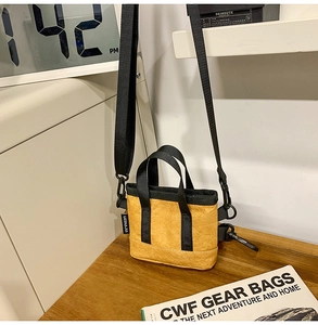 Détail du sac bandoulière jaune en papier DuPont avec poignées et sangle noires
