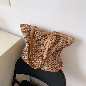Détails de la texture en paille tressée et des poignées en cuir du sac de vacances