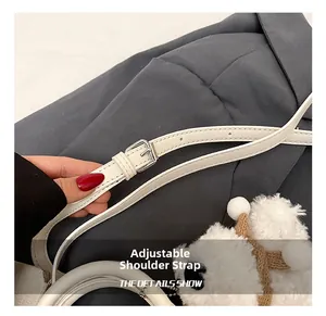 Détail d'une bandoulière réglable en cuir PU blanc avec boucle argentée et breloque