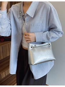 Sac seau argenté métallisé avec chaîne et bandoulière porté par un mannequin