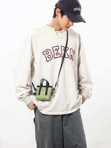 Mini sac cabas vert haricot minimaliste avec bandoulière noire porté par un modèle
