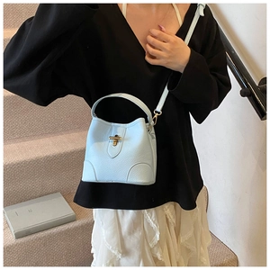 Detail of light blue bucket bag with gold twist lock and fine textured leather finish
