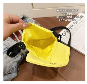 Dettaglio dell'interno della borsa a tracolla in nylon giallo con chiusura a pressione