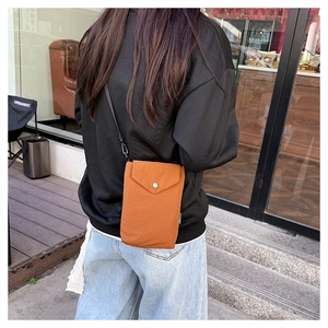 Vista posteriore di una modella con borsa a tracolla arancione in nylon per cellulari