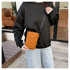 Dettaglio mini borsa porta cellulare color caramello in nylon con chiusura a scatto metallica
