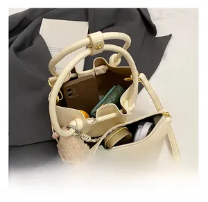 Top view of cream bucket bag showing interior storage capacity and matching pouch
