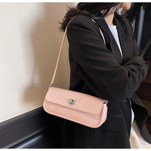 Rosafarbene Lackleder-Tasche mit Silberverschluss, getragen von einem Model im schwarzen Blazer