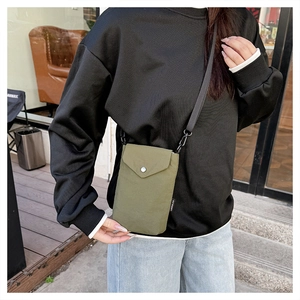 Dettaglio della borsa per cellulare in nylon verde oliva con chiusura a scatto e tracolla