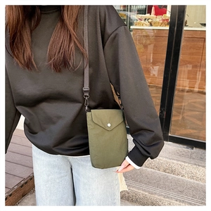 Dettaglio della borsa a tracolla in nylon verde militare con bottone a scatto